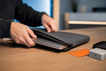 Die Kante des Laptops wird in eine schlanke Schutzhülle gesteckt